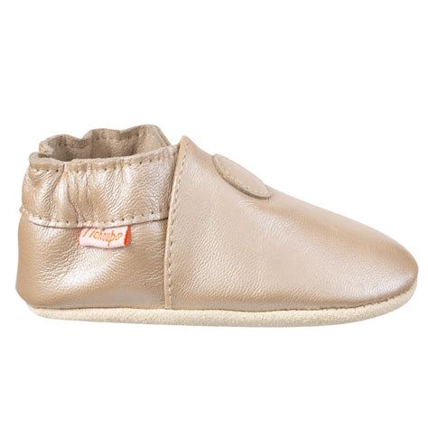 chaussons en cuir souple pour bébé sur un sol en bois
