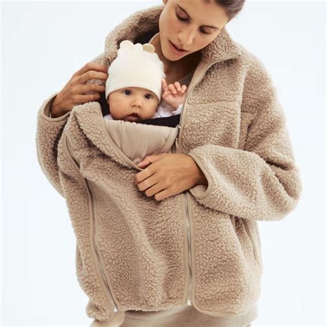 parent portant bébé dans une veste de portage en hiver