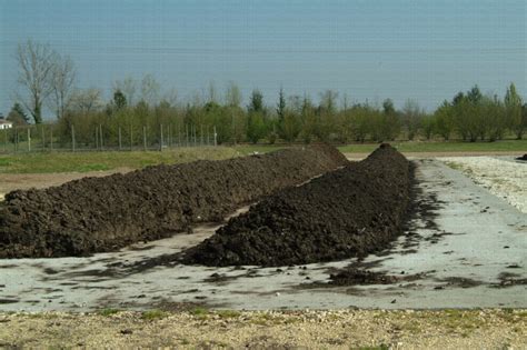 Image d'une machine retournant un andain de compost sur une plateforme industrielle
