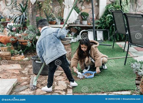 Enfant balayant des feuilles dans le jardin