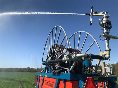 Enrouleur avec canon d'irrigation en fonctionnement dans un champ