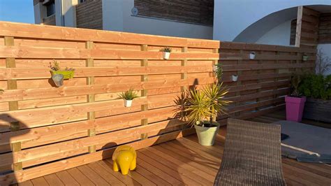 Exemple de jardinière brise-vue en bois ajouré sur un balcon