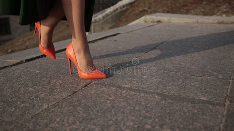 une femme élégante aux talons hauts montant un escalier en pierre