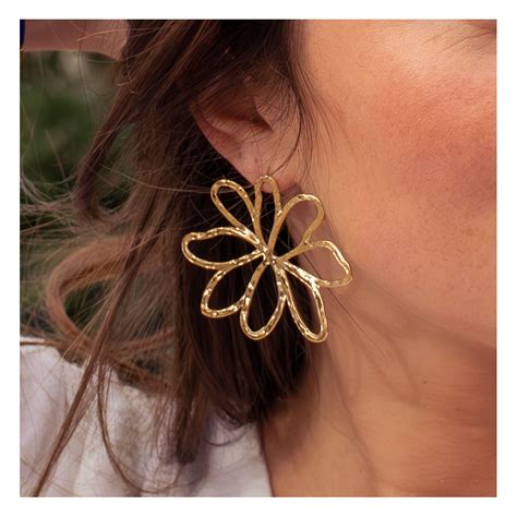 Image d'une femme portant des boucles d'oreilles en noisetier, souriante et sereine