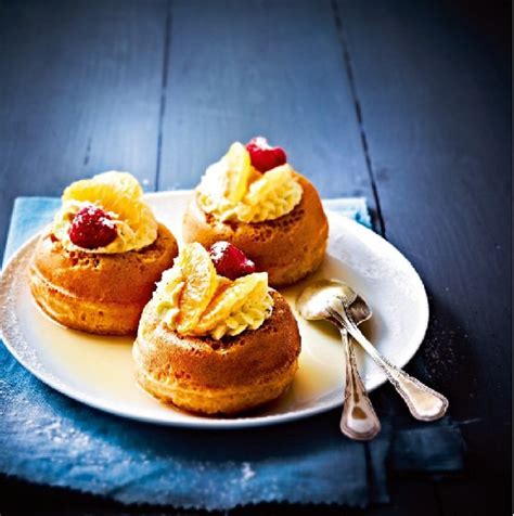 Plat de babas au rhum décorés de crème chantilly et de fruits rouges