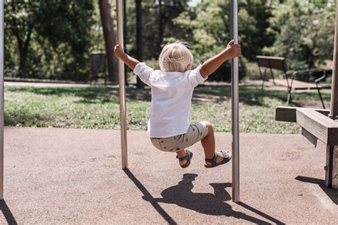 Enfant grimpant sur un poteau d'aire de jeux