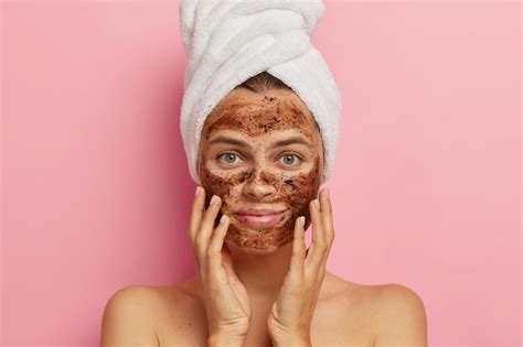 Femme appliquant un gommage au café sur le visage