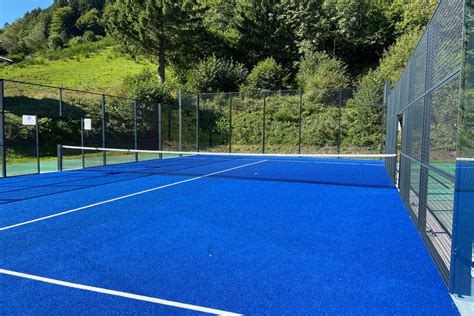 Terrain de padel avec parois vitrées et gazon synthétique