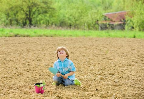 Enfant plantant une petite fleur avec un transplantoir