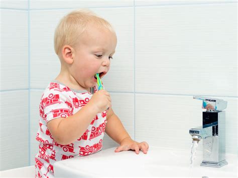 Enfant fermant le robinet en se brossant les dents