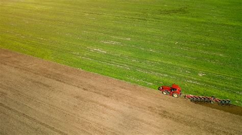 Champ agricole avec un tracteur épandant de l'engrais