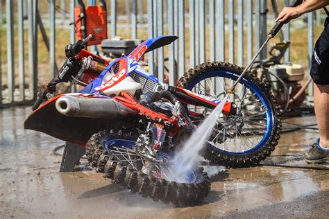 Motocross bike being serviced, showing engine and various lubricants