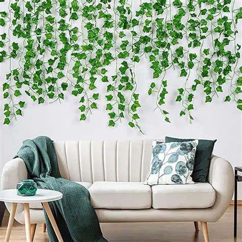 Installation de guirlandes de lierre artificiel sur un mur de salon pour un effet végétal