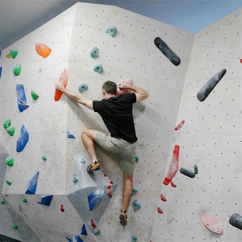 Grimpeur en équilibre sur un mur d'escalade