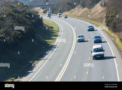Voiture circulant sur une route bordée d'herbes fauchées pour la visibilité