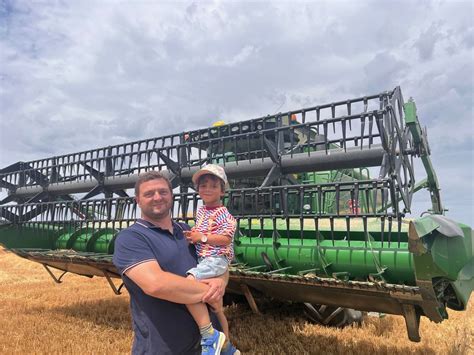 Portrait d'un agriculteur devant sa moissonneuse à Allonnes
