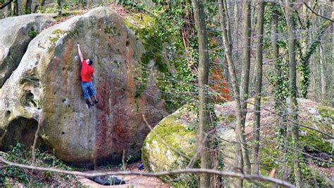 Grimpeur réalisant un réta sur un bloc de Fontainebleau