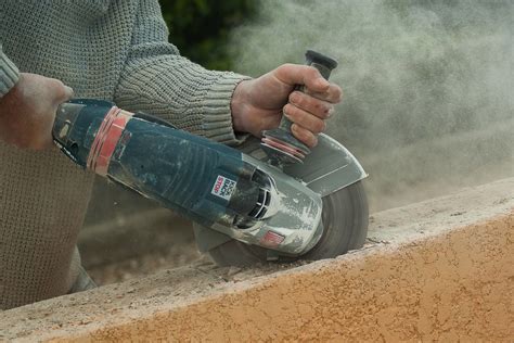 Utilisation d'une meuleuse pour couper une bordure en béton