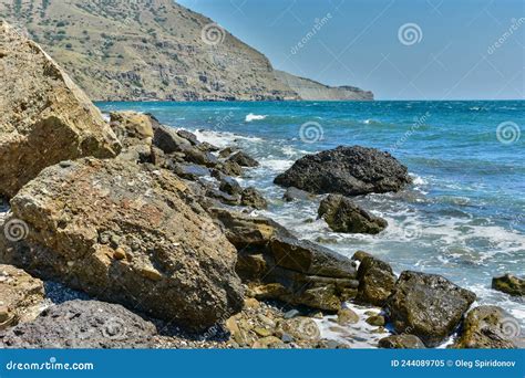 Enfant marchant sur des rochers au bord de la mer avec des bottes