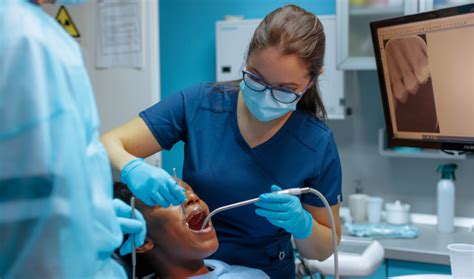 Image d'un dentiste utilisant une canule d'aspiration pendant une intervention