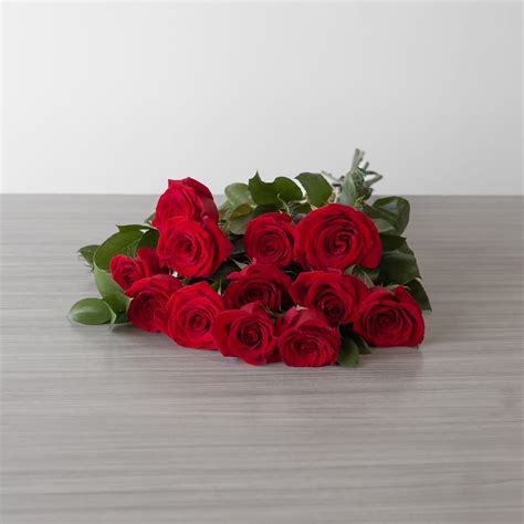 Arrangement de roses rouges de longue tige avec du feuillage