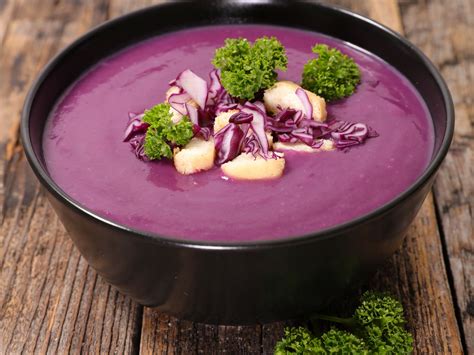 Bol de soupe au chou rouge fumant avec garniture de noix et crème fraîche