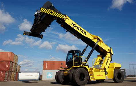 Vue d'ensemble d'un télescopique JCB réalisant des travaux de manutention de fumier dans une cour de ferme