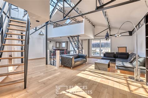 vue d'ensemble d'un loft à Brooklyn avec verrière, table en bois massif et éclairage industriel