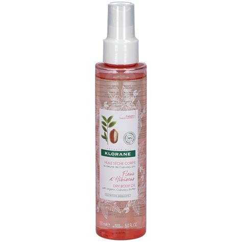Flacon d'huile sèche Klorane fleur d'hibiscus dans un cadre naturel