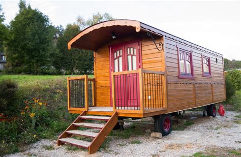 Photo d'une roulotte (Hut) dans un cadre naturel, suggérant un hébergement pour une formation en permaculture