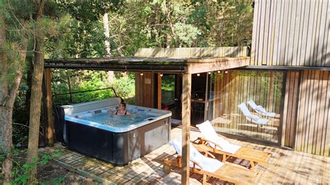 Photo d'une tiny house avec un jacuzzi extérieur sous les étoiles, dans un cadre naturel