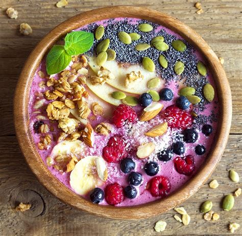 Un smoothie bowl coloré aux baies et granola avec des graines de chia
