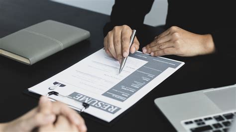 Un étudiant en entretien professionnel face à un recruteur analysant des documents