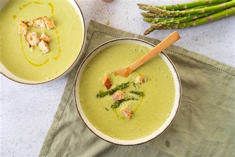 Bol de velouté d'asperges avec petits pois et croûtons