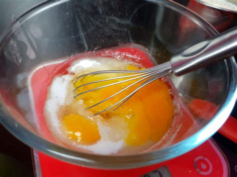 Un bol contenant un mélange d'œufs et de sucre blanchi