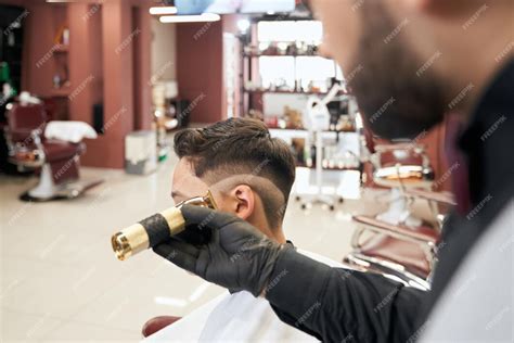 Coiffeur utilisant une tondeuse pour réaliser un dégradé