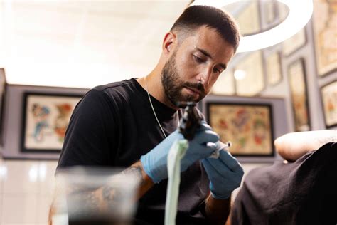 Un tatoueur travaillant sur un motif traditionnel vietnamien dans un salon moderne à Saigon