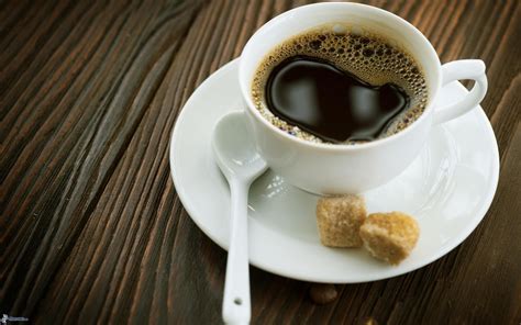 Photo de présentation montrant une tasse de café noir et des grains de café frais