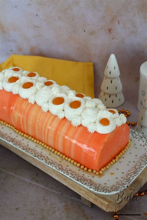 une bûche de Noël élégante avec un glaçage miroir orange et des décorations en chocolat