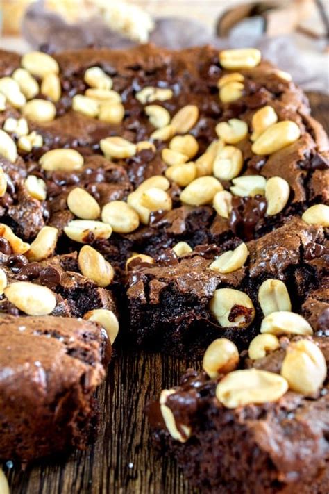 une vue rapprochée d’un entremets au chocolat décoré de cacahuètes caramélisées et éclats de noisettes