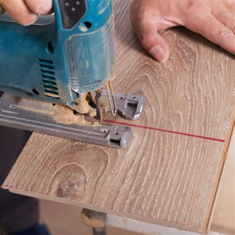 Utilisation d'une scie sauteuse pour découper une lame de parquet