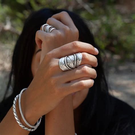 Gros plan sur une bague hortensia en argent portée sur un doigt