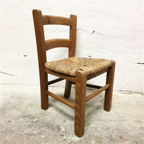 une vieille chaise en bois et paille posée dans un atelier de menuiserie