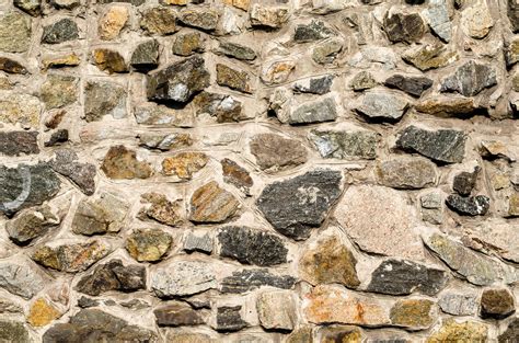 Détail de la texture d'une pierre naturelle clivée utilisée en bordure de jardin