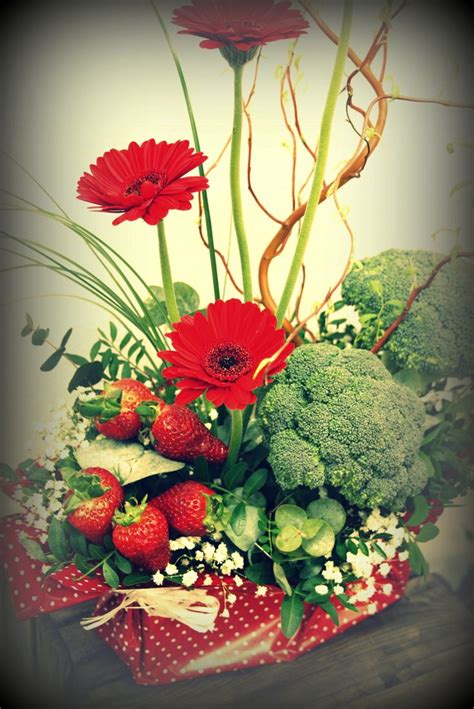 Composition florale intégrant des fruits frais et des fleurs de saison sur une table de réception