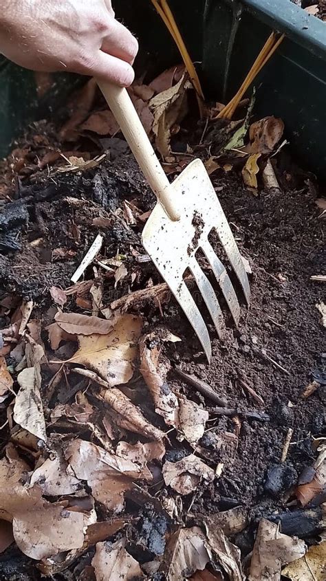 Compost pile being turned with a pitchfork