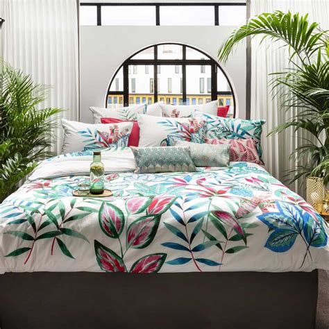 Une chambre à coucher lumineuse décorée avec une housse de couette aux motifs d'hibiscus tropicaux