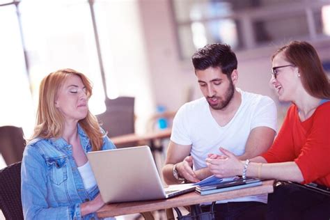 Étudiants travaillant en groupe sur un projet professionnel collaboratif dans un environnement universitaire