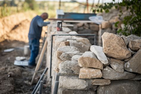 Couple travaillant à la restauration d'un mur en pierre
