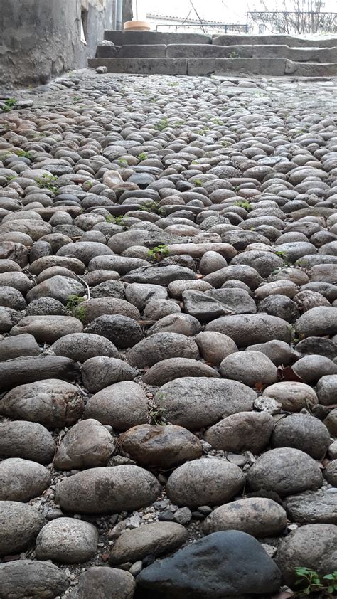 Photo d'une allée de jardin réalisée avec des galets roulés et des bordures en métal